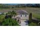 A high angle view presents the two-story residence, accentuated by a mature palm tree and verdant landscaping at 3921 Kearsney Abbey Cir, Dover, FL 33527