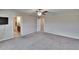 Spacious carpeted main bedroom featuring a ceiling fan and an ensuite bathroom at 3921 Kearsney Abbey Cir, Dover, FL 33527