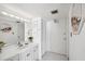 Bright bathroom featuring white cabinets, a large mirror, and updated fixtures at 450 S Gulfview Blvd # 605, Clearwater Beach, FL 33767