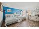 Bright bedroom featuring two beds, blue accent wall, and a view of the outdoors at 450 S Gulfview Blvd # 605, Clearwater Beach, FL 33767