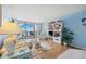 Cozy living room with nautical decor, wood floors, and sliding glass doors leading to the condo balcony at 450 S Gulfview Blvd # 605, Clearwater Beach, FL 33767