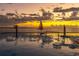 Tranquil sunset reflecting on pool with sailboat in the background at 450 S Gulfview Blvd # 605, Clearwater Beach, FL 33767