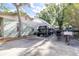 View of the driveway with a large tent, ideal for parking vehicles and trailers, surrounded by lush greenery at 510 1/2 Ulelah Ave, Palm Harbor, FL 34683
