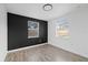 Bedroom with modern gray accent wall, two windows, and neutral flooring at 5220 Pine St, Seffner, FL 33584