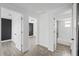 Bright hallway featuring modern gray flooring, crisp white walls, and access to multiple rooms at 5220 Pine St, Seffner, FL 33584