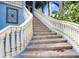 Close-up of the exterior stairs with white railing leading to a blue home at 541 Treviso Dr, Apollo Beach, FL 33572