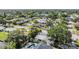 Aerial view showcasing neighborhood, lake, mature trees, private pool, and solar panels at 6041 16Th Ne Ln, St Petersburg, FL 33703
