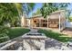 Beautiful backyard with a fire pit, stone paver pathway, lush landscaping, and covered patio at 6041 16Th Ne Ln, St Petersburg, FL 33703