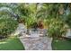 Beautiful backyard with a stone paver pathway, fire pit, lush landscaping, and an outdoor seating area at 6041 16Th Ne Ln, St Petersburg, FL 33703