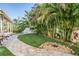 Landscaped backyard featuring verdant artificial grass, lush bamboo, stone pavers, and a charming water feature at 6041 16Th Ne Ln, St Petersburg, FL 33703