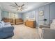 Spacious bedroom with blue walls featuring custom molding, two cribs, dresser and comfortable seating at 6041 16Th Ne Ln, St Petersburg, FL 33703
