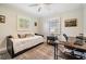 Neutral bedroom with a daybed, shuttered windows, an area rug, and office space at 6041 16Th Ne Ln, St Petersburg, FL 33703