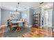 Bright dining area featuring modern light fixture, wood floors, adjacent to kitchen and bathroom at 6041 16Th Ne Ln, St Petersburg, FL 33703