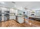 Modern kitchen with white cabinets, stainless steel appliances, and wood floors flowing into the living space at 6041 16Th Ne Ln, St Petersburg, FL 33703