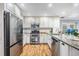 Beautiful kitchen featuring stainless steel appliances, wooden floors, granite counters, and white cabinets at 6041 16Th Ne Ln, St Petersburg, FL 33703