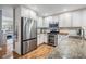 Bright kitchen featuring stainless steel appliances, wooden floors, granite counters, and white cabinets at 6041 16Th Ne Ln, St Petersburg, FL 33703