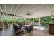 Covered outdoor patio with comfortable seating, ceiling fan, and a bar area overlooking the yard at 6041 16Th Ne Ln, St Petersburg, FL 33703