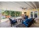 Covered outdoor patio with comfortable seating, ceiling fan, swing, and a bar area overlooking the yard at 6041 16Th Ne Ln, St Petersburg, FL 33703