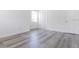 Sunlit bedroom featuring gray wood floors, white walls, and a closet at 6906 N Lynn Ave, Tampa, FL 33604