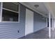 A well-maintained exterior featuring a side entrance with white pillars and blue siding at 6906 N Lynn Ave, Tampa, FL 33604