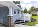 Charming home featuring blue siding, white trim, a small deck, and manicured landscaping at 6906 N Lynn Ave, Tampa, FL 33604