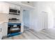 Kitchen with stainless steel appliances, white cabinets, and light gray wood floors at 6906 N Lynn Ave, Tampa, FL 33604