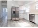 Modern kitchen with stainless steel appliances, white cabinets and light gray wood floors at 6906 N Lynn Ave, Tampa, FL 33604
