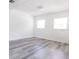 Bright empty room with white walls and light gray wood flooring at 6906 N Lynn Ave, Tampa, FL 33604