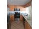 Modern kitchen with stainless steel appliances, granite countertops, tile backsplash, and wooden cabinets at 70 Durham Ct, Palm Harbor, FL 34683