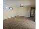 Bright living room boasts neutral carpeting, a ceiling fan, and natural light from the high windows at 70 Durham Ct, Palm Harbor, FL 34683
