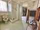 Outdated bathroom featuring a glass shower, toilet, and floral wallpaper, needing renovation at 701 64Th Ave, St Pete Beach, FL 33706