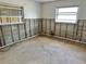 Bedroom with partially exposed walls, two windows, and concrete flooring, needing remodeling at 701 64Th Ave, St Pete Beach, FL 33706