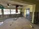 Living room renovation shows exposed walls, missing ceiling, damaged floor, natural light through windows at 701 64Th Ave, St Pete Beach, FL 33706