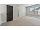 Bright bedroom with carpeted floors, three windows, and a dark door at 7258 Kodiak Ln, Sarasota, FL 34240