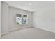Bright bedroom featuring neutral carpet, two windows, and fresh white paint at 7258 Kodiak Ln, Sarasota, FL 34240