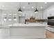 Modern kitchen with white cabinets, a center island, and sleek pendant lighting at 7258 Kodiak Ln, Sarasota, FL 34240