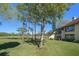 Scenic backyard view overlooking a lush golf course, mature trees, and a bright blue sky at 8003 Bardmoor Pl # 204, Seminole, FL 33777