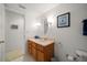 Bathroom features a wood vanity, neutral countertops, oval mirror, and decorative sailboat art at 8003 Bardmoor Pl # 204, Seminole, FL 33777