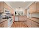 Traditional kitchen with tile floor, light wood cabinetry, and white appliances at 8003 Bardmoor Pl # 204, Seminole, FL 33777