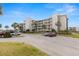 Condo building exterior with parking lot and palm trees on a sunny day at 8141 Aquila St # 322, Port Richey, FL 34668