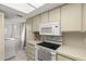 Efficient kitchen layout with modern appliances and a laundry area for added convenience at 8141 Aquila St # 322, Port Richey, FL 34668
