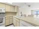 Bright kitchen with white cabinets and breakfast bar providing an eat-in space at 8141 Aquila St # 322, Port Richey, FL 34668