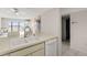 Bright kitchen with double sink, tiled countertop, and white appliances at 8141 Aquila St # 322, Port Richey, FL 34668