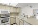 Bright kitchen features tile countertops and white appliances, perfect for everyday cooking at 8141 Aquila St # 322, Port Richey, FL 34668