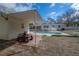 Backyard with inground pool, brick patio, covered area, and riding mower at 9618 N 55Th St, Temple Terrace, FL 33617
