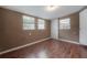 A bedroom illuminated by natural light shows multiple windows and wood laminate flooring at 9618 N 55Th St, Temple Terrace, FL 33617