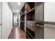 Spacious walk-in closet with custom dark wood shelving and mirrored door at 9618 N 55Th St, Temple Terrace, FL 33617