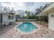 The backyard has a classic in-ground pool, a patio, and is surrounded by mature trees at 9618 N 55Th St, Temple Terrace, FL 33617