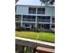 Exterior view of a three-story condominium with screened balconies and well-maintained lawn at 9914 Indian Key Trl # 32, Seminole, FL 33776