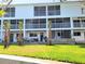 Exterior view of a three-story condominium with screened balconies and well-maintained lawn at 9914 Indian Key Trl # 32, Seminole, FL 33776
